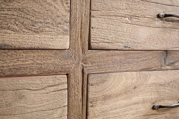Close-up of the Iya Reclaimed Wood Chest of Drawers by nkuku, Large size in Natural finish, showcasing its rustic wood grain and texture at the drawer frame intersection with partial metal handles on the right.