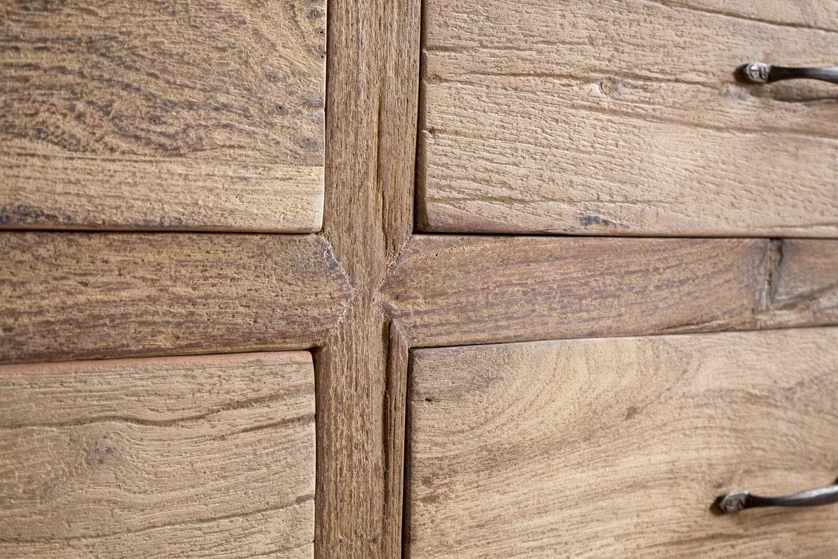 Close-up of the Iya Reclaimed Wood Chest of Drawers by nkuku, Large size in Natural finish, showcasing its rustic wood grain and texture at the drawer frame intersection with partial metal handles on the right.