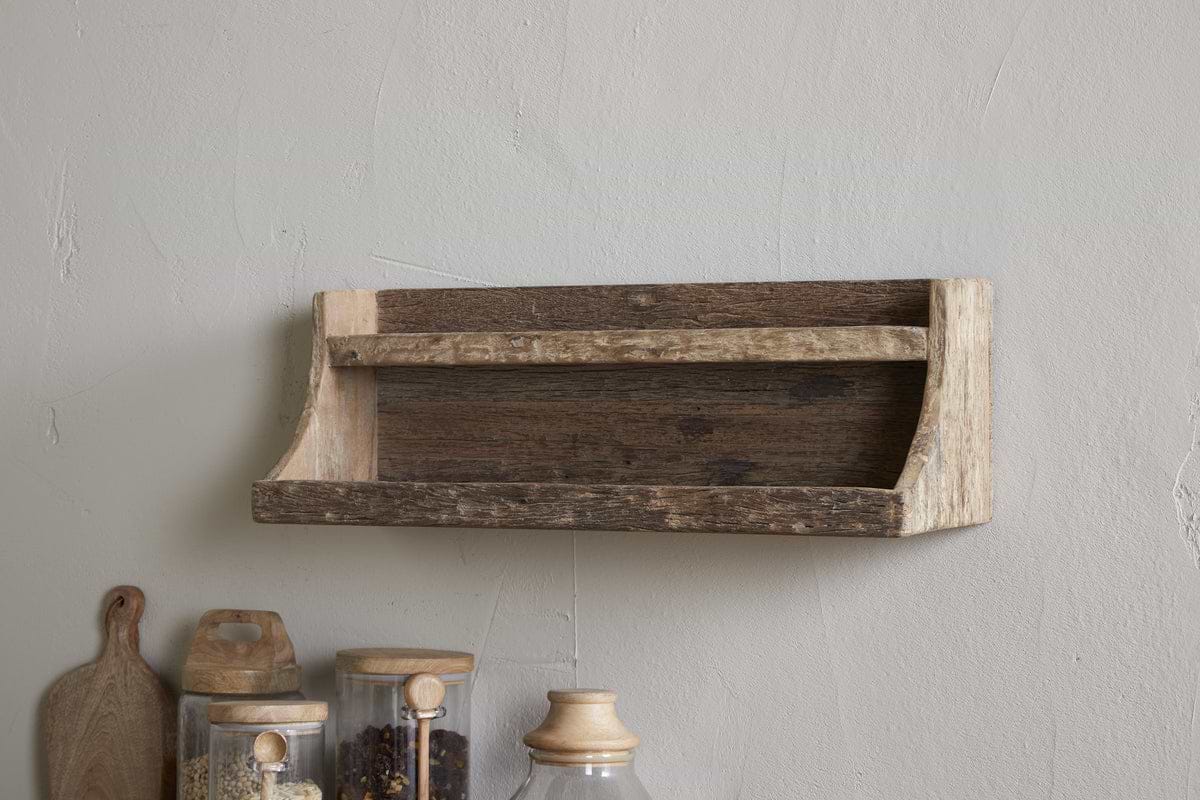 The nkuku Ibo Reclaimed Wood Storage Shelf - Natural adds rustic charm, mounted above a countertop with glass jars, a wooden cutting board, and a ceramic container—ideal for stylish kitchen storage.
