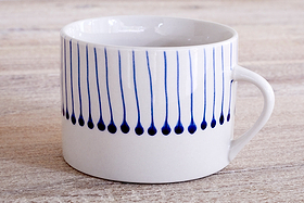 The nkuku Iba Mug - Indigo - Large (Set of 2) features a white ceramic body with simple handles and vertical blue lines ending in dots, inspired by Iba design, spaced around the upper half. Perfect for modern coffee moments.