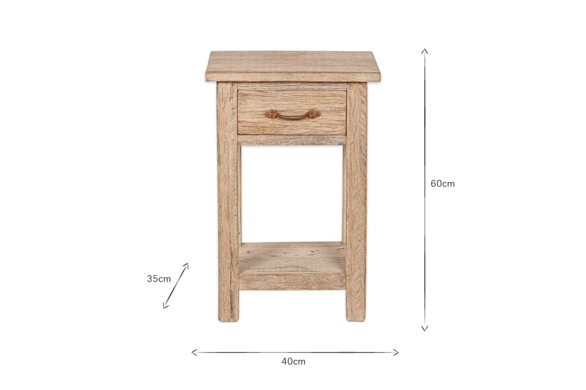 The Ibo Reclaimed Wood Bedside Table - Natural by nkuku is a rustic bedside table crafted from reclaimed wood, featuring one drawer with a dark metal pull, an open shelf below, and measures 60cm H x 40cm W x 35cm D.