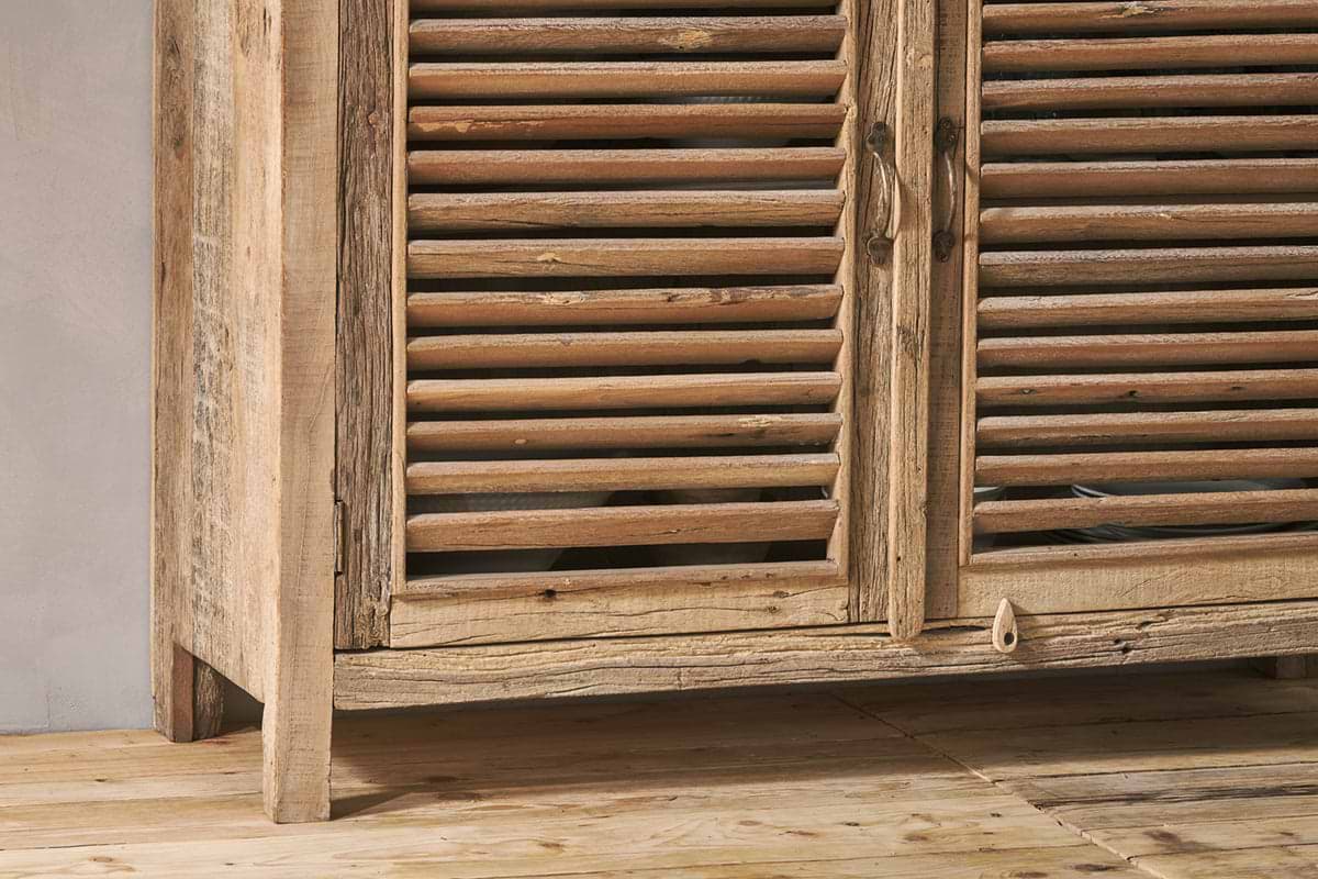 Close-up of the Ibo Reclaimed Wooden Slatted Sideboard by nkuku, featuring artisan-crafted louvered doors, weathered natural finish, ornate metal handles, and a small wooden latch accent on the lower panel.