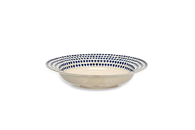 The Indigo Drop Pasta Bowl - Cream & Indigo by nkuku is a handmade, shallow ceramic bowl with a cream base and handpainted blue teardrop rim, shown from the side against a plain white background.