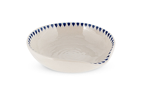 The Indigo Drop Spoon Rest - Cream & Indigo by nkuku is a shallow, round handcrafted bowl with an off-white glaze, uneven rim, and blue teardrop ceramic edging, ideal as a decorative spoon rest. Plain white background.