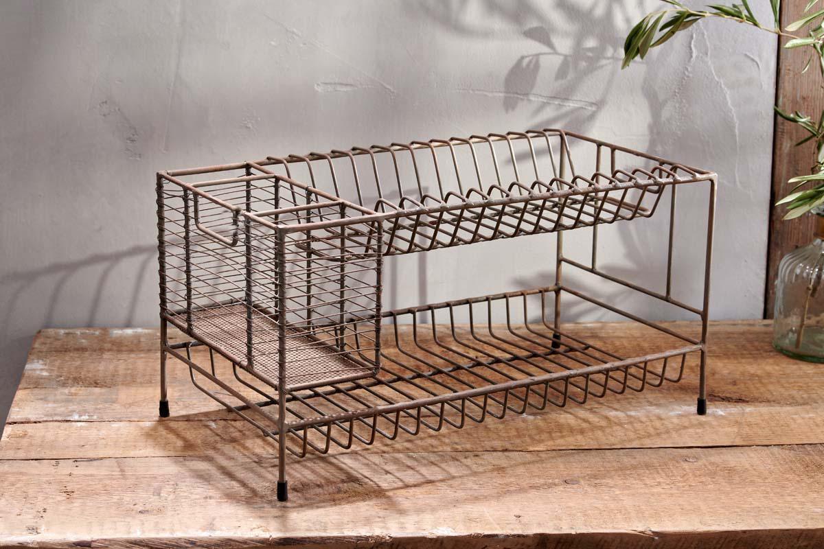The nkuku Inkollu Dish Rack features two tiers of open wire metal shelves and slim legs for a rustic, industrial look. Perfect for drying plates and utensils, it sits stylishly on your countertop, casting airy shadows as sunlight streams in.