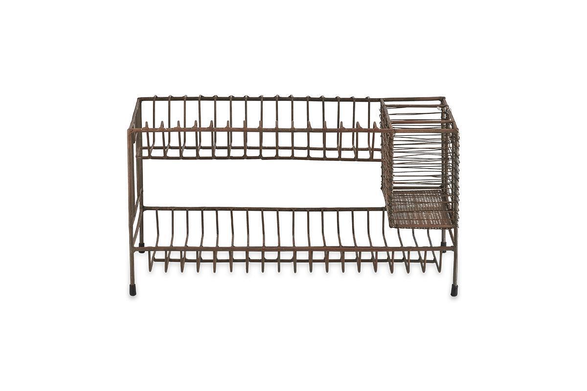 The Inkollu Dish Rack by nkuku is a brown, rectangular dish rack with an aged brass finish, two tiers for plates, a right-side utensil compartment, and a wire-frame design on four short legs.