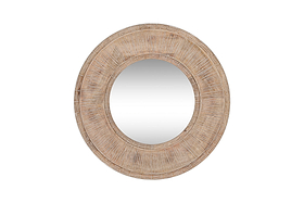 The nkuku Itwa Mango Wood Carved Mirror features a wide, textured frame with a natural finish and sunburst-effect carved lines, creating a unique focal point against any plain white wall.