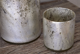 Two Kunjari Tealight Holders by nkuku in rustic gold with a weathered, speckled finish sit on a wooden surface—ideal for adding charm and classic rustic style to your space.