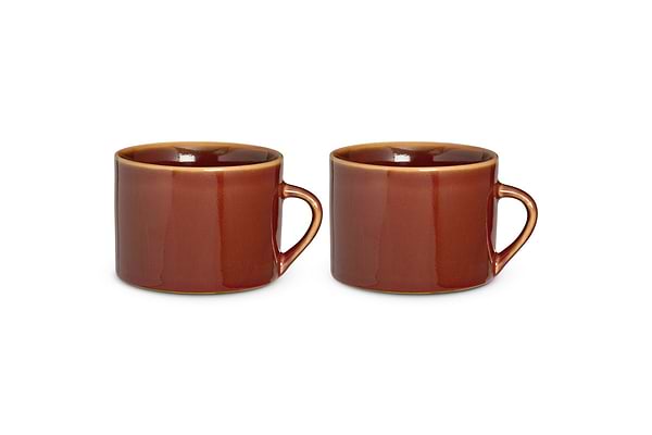 Two large nkuku Kalini Mugs in glossy amber, kiln-fired for durability, sit side by side against a white background. Each mug has a round handle, slightly rounded lip, and smooth straight-sided shape. Sold as a set of 2.
