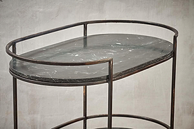 The Karoko Marble Drinks Table by nkuku features an oval black marble top with white veining, slim black metal legs, and a matching rim—a minimalist standout for entertaining in modern spaces.