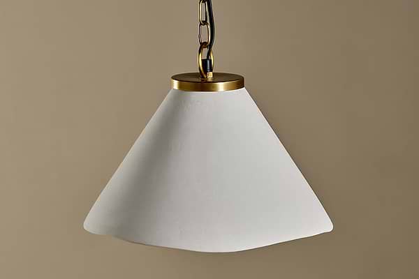 The Kiara Organic Shape Ceramic Pendant Light by nkuku features an off-white, asymmetrical shade and antique brass fixture, offering handcrafted elegance and stylish lighting to any space.