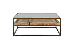The nkuku Luzon Iron & Mango Wood Display Coffee Table in brass features a modern square glass top, black iron frame, two woven wicker drawers, and mango wood trays for added warmth and texture against a white backdrop.