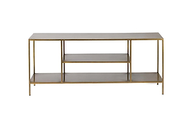 The Mahi Media Standing Shelf by nkuku features a slim gold metal frame and three rectangular wooden shelves, including two open brass shelves in the center, ideal for organizing entertainment equipment. Photographed against a plain white background.