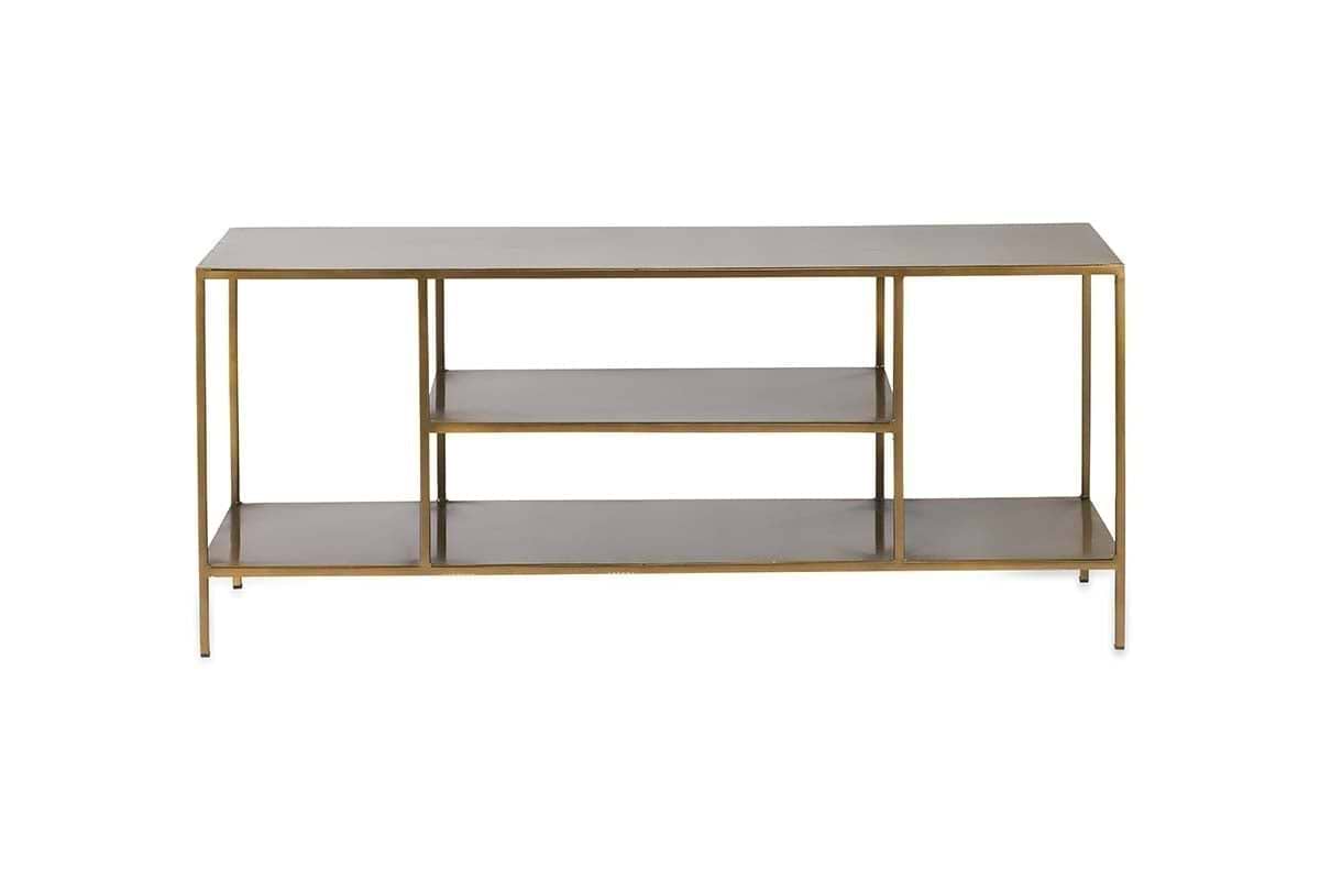 The Mahi Media Standing Shelf by nkuku features a slim gold metal frame and three rectangular wooden shelves, including two open brass shelves in the center, ideal for organizing entertainment equipment. Photographed against a plain white background.
