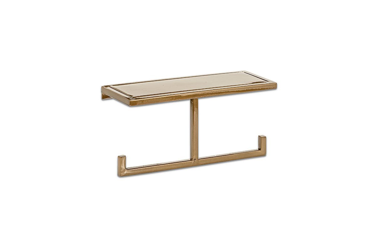 The nkuku Mahi Wall Mounted Toilet Roll Holder is a gold-colored brass piece that combines style and function with its minimal design, serving as a modern wall shelf with unique hooks and a single vertical support bar.