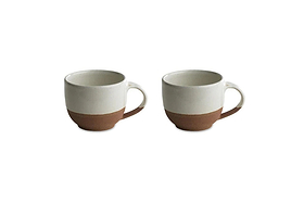 The nkuku Mali White and Terracotta mugs feature a minimalist design with an off-white glazed top and handmade terracotta base, combining rustic charm and modern style. Set of two mugs shown on a white background.