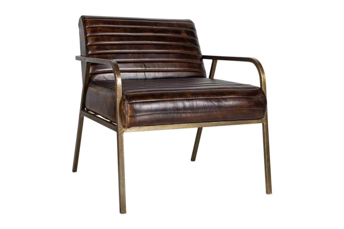 The Mirai Ribbed Leather Armchair by nkuku features a vintage-inspired design with handmade dark brown buffalo leather cushions, slim bronze-finished metal armrests and legs, and a minimalist industrial aesthetic against a plain white background.