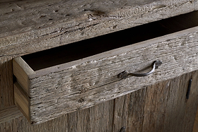 A close-up of the Ibo Reclaimed Wood Sideboard - Natural by nkuku shows its partially open drawer, rustic charm, weathered wood textures, and simple metal handle, embodying authentic sideboard style.