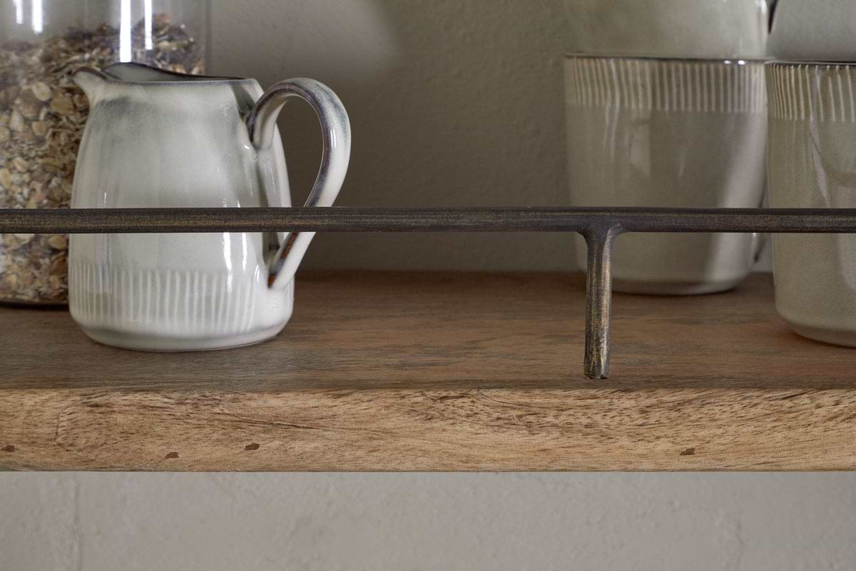 A close-up of the nkuku Meera Mango Wood & Iron Gallery Shelf – Natural, displaying an off-white ceramic pitcher and two cups with subtle gray accents, plus a jar of oats. A dark iron rail provides stylish support to this elegant kitchen storage piece.