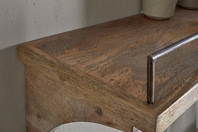 Close-up of the nkuku Meera Mango Wood & Iron Gallery Shelf - Natural, showcasing its natural grain and smooth surface with a metal rail—perfect for kitchen storage. A light ceramic piece sits right, set against an off-white wall.