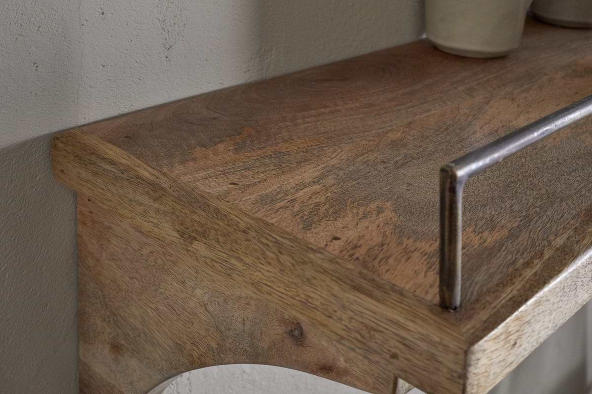 Close-up of the nkuku Meera Mango Wood & Iron Gallery Shelf - Natural, showcasing its natural grain and smooth surface with a metal rail—perfect for kitchen storage. A light ceramic piece sits right, set against an off-white wall.