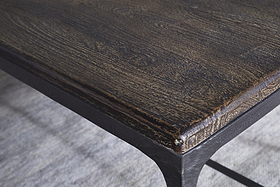 Close-up of the nkuku Sita Reclaimed Wood & Iron Coffee Table in Chocolate Brown, featuring a rounded reclaimed wood top with visible grain and black metal frame, adding modern style over a light textured rug.