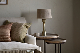 The Marpha Antique Brass Table Lamp by nkuku sits elegantly on the bedside table, offering warm accent lighting to the room.
