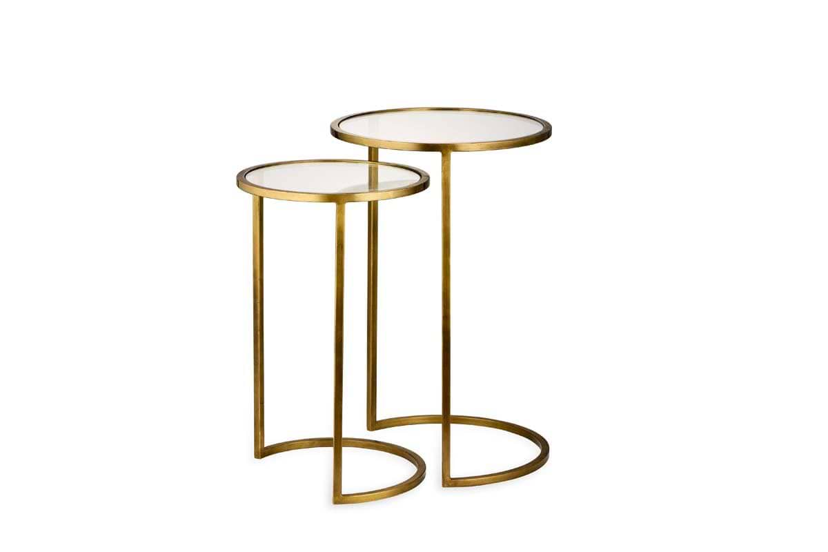 The Nakuru Iron & Glass Side Table Set by nkuku features two nesting tables with round glass tops and stylish brass C-shaped bases.