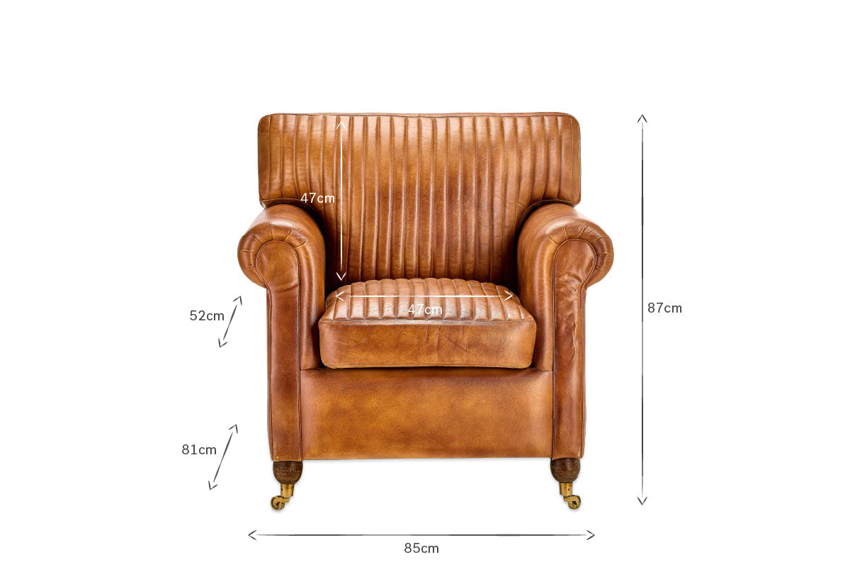 The nkuku Narwana Ribbed Leather Armchair - Aged Tan is a front-facing brown leather chair with ribbed stitching, small wheels on the legs, and measures 87x85x81cm (HWD); seat height 47cm, seat depth 49cm, armrest height 52cm.
