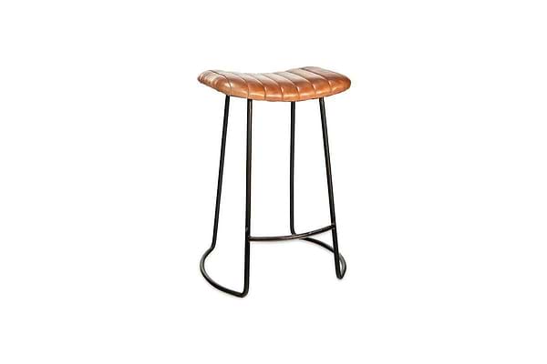 The nkuku Narwana Ribbed Leather Stool in Aged Tan (Small) features a padded tufted seat, distressed brown ribbed leather, and slim black metal legs, shown against a white background.