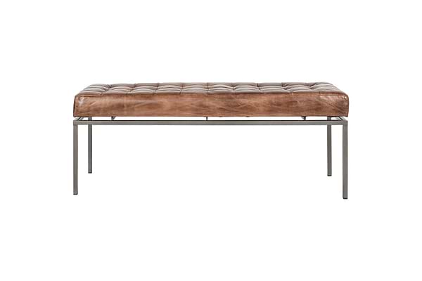 The nkuku Nasan Leather Upholstered Bench features a tan tufted cushion, slim black-finished metal legs, and a solid iron frame for a modern minimalist look against a plain white background.