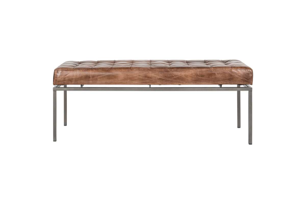 The nkuku Nasan Leather Upholstered Bench features a tan tufted cushion, slim black-finished metal legs, and a solid iron frame for a modern minimalist look against a plain white background.