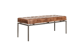 The Nasan Leather Upholstered Bench by nkuku features a rectangular tan leather tufted cushion and minimalist solid iron frame with slender legs, showcasing a versatile design against a plain white background.