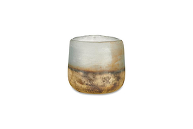 The Ngolo Tealight Holder - Aged Smoke by nkuku features a small, rounded design handmade from recycled glass, with a frosted white upper half blending into a gold and bronze textured base that adds atmospheric light to any space.