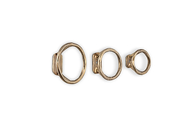 The nkuku Olani Bathroom Hooks - Antique Brass (Set of 3) feature handcrafted, unevenly textured metal rings in varying sizes, adding an organic, spa-inspired accent to your bathroom décor.