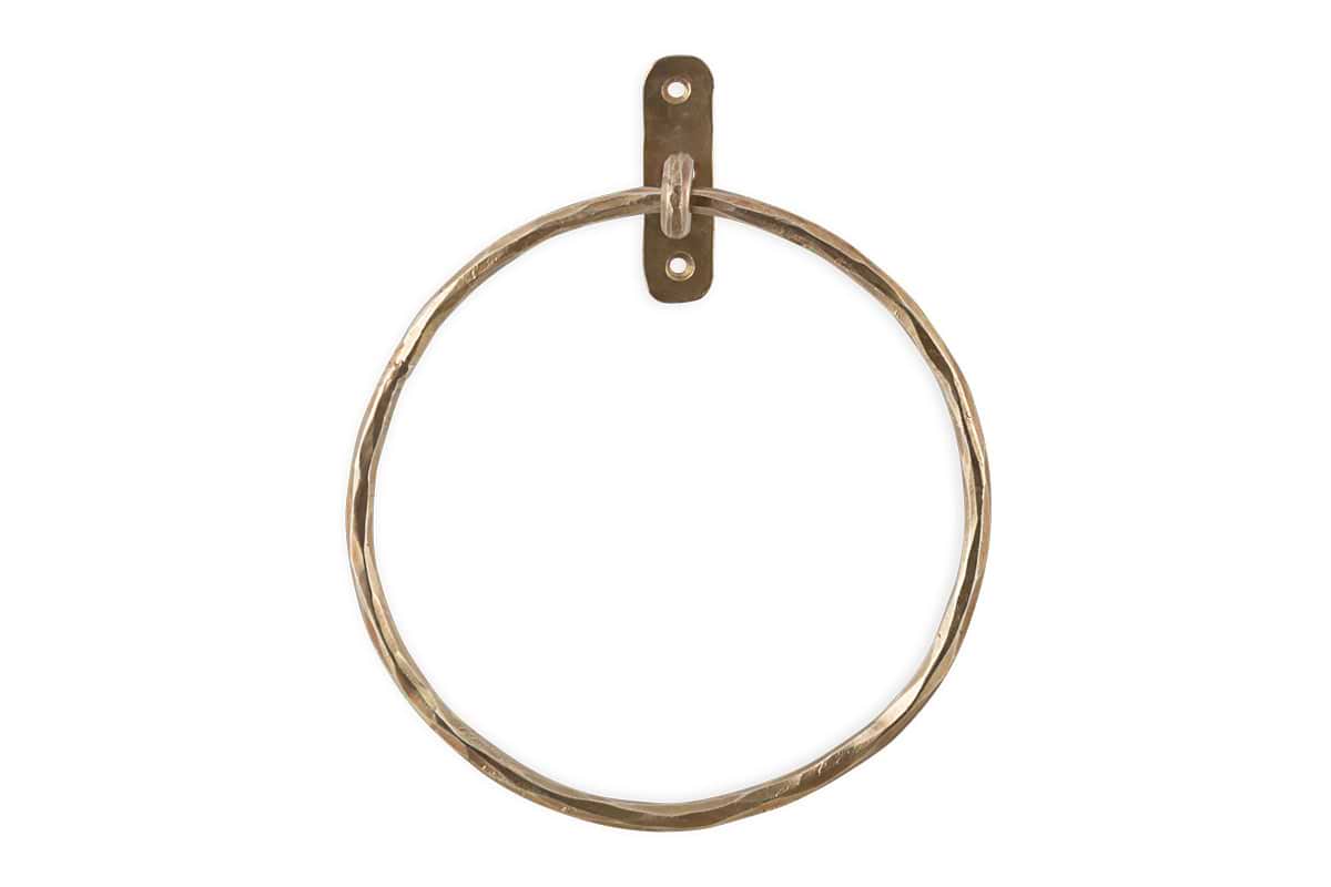 The Olani Towel Ring - Antique Brass by nkuku features a hammered brass finish and a rectangular wall plate with two screw holes, creating an elegant vertical towel holder perfect for any bathroom.