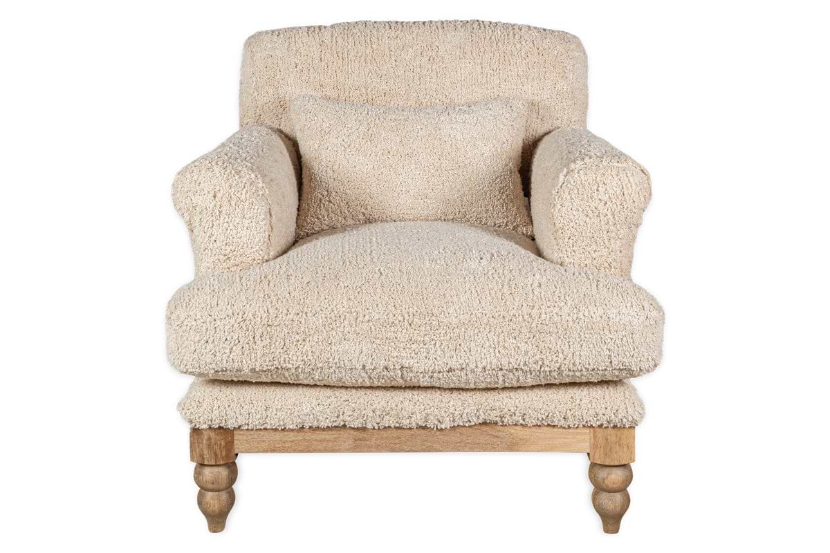 The nkuku Otas Teddy Cotton Armchair in off white features plush, textured fabric, thick rounded arms, a matching cushion, and four turned natural mango wood legs. The background is plain white.