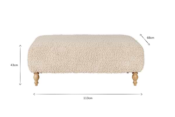 The Otas Teddy Ottoman - Off White by nkuku features fluffy, cream boucle upholstery, a solid mango wood base, and carved legs. Dimensions: 113cm W x 68cm D x 43cm H. A stylish blend of comfort and elegance for any space.