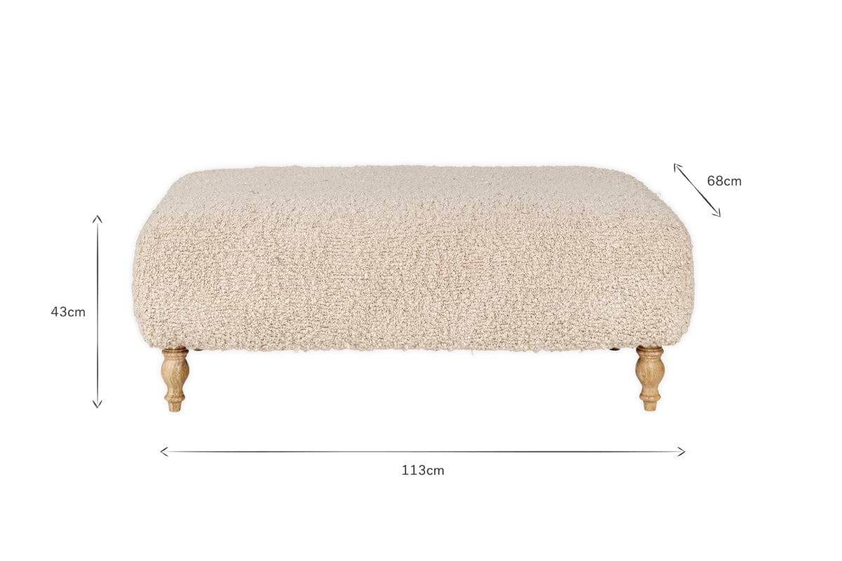 The Otas Teddy Ottoman - Off White by nkuku features fluffy, cream boucle upholstery, a solid mango wood base, and carved legs. Dimensions: 113cm W x 68cm D x 43cm H. A stylish blend of comfort and elegance for any space.