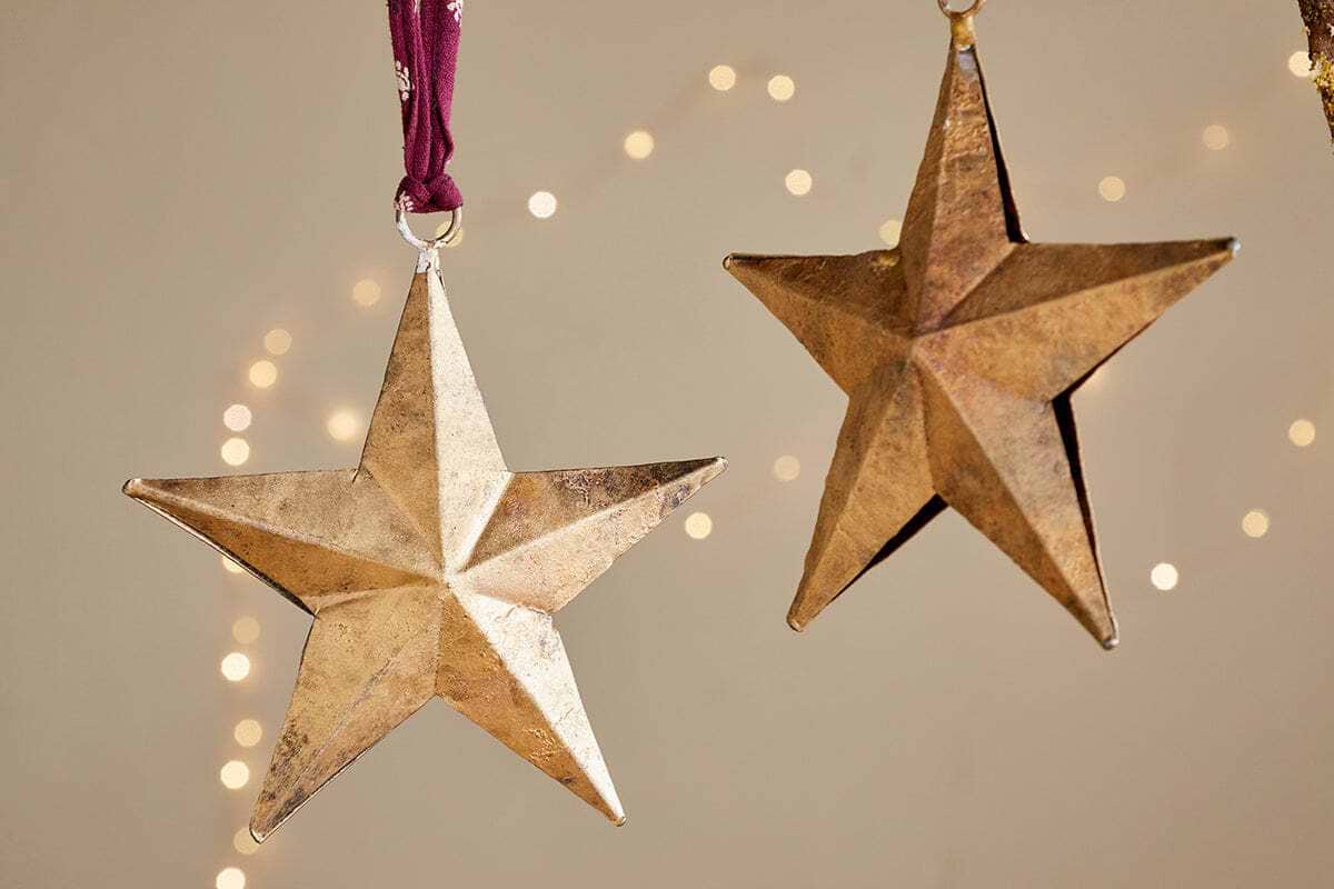 The Roshani Star Baubles - Antique Brass (Set of 2) by nkuku make a charming festive display.