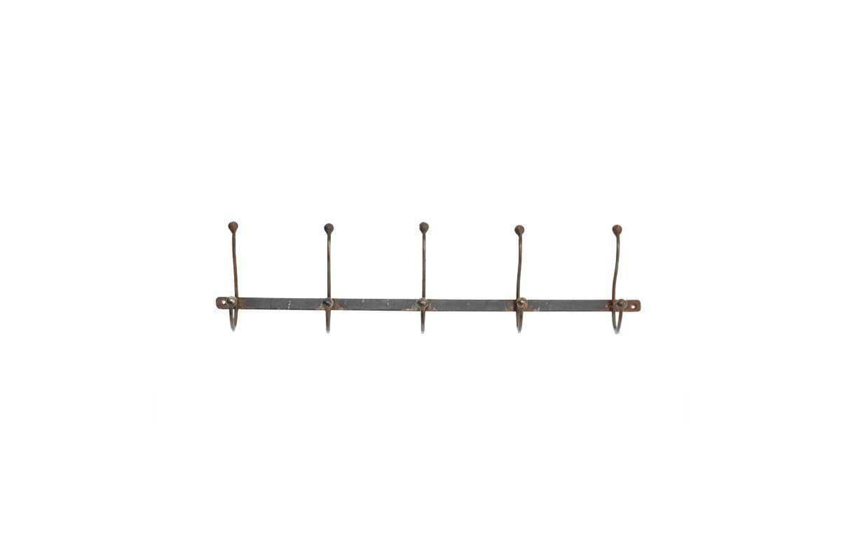 The nkuku Rama Iron Hook is a rustic, horizontal metal wall rack featuring five evenly spaced, upward-curving iron hooks. Visible screws secure each hook to the backplate, making it ideal for hallway storage and organization.