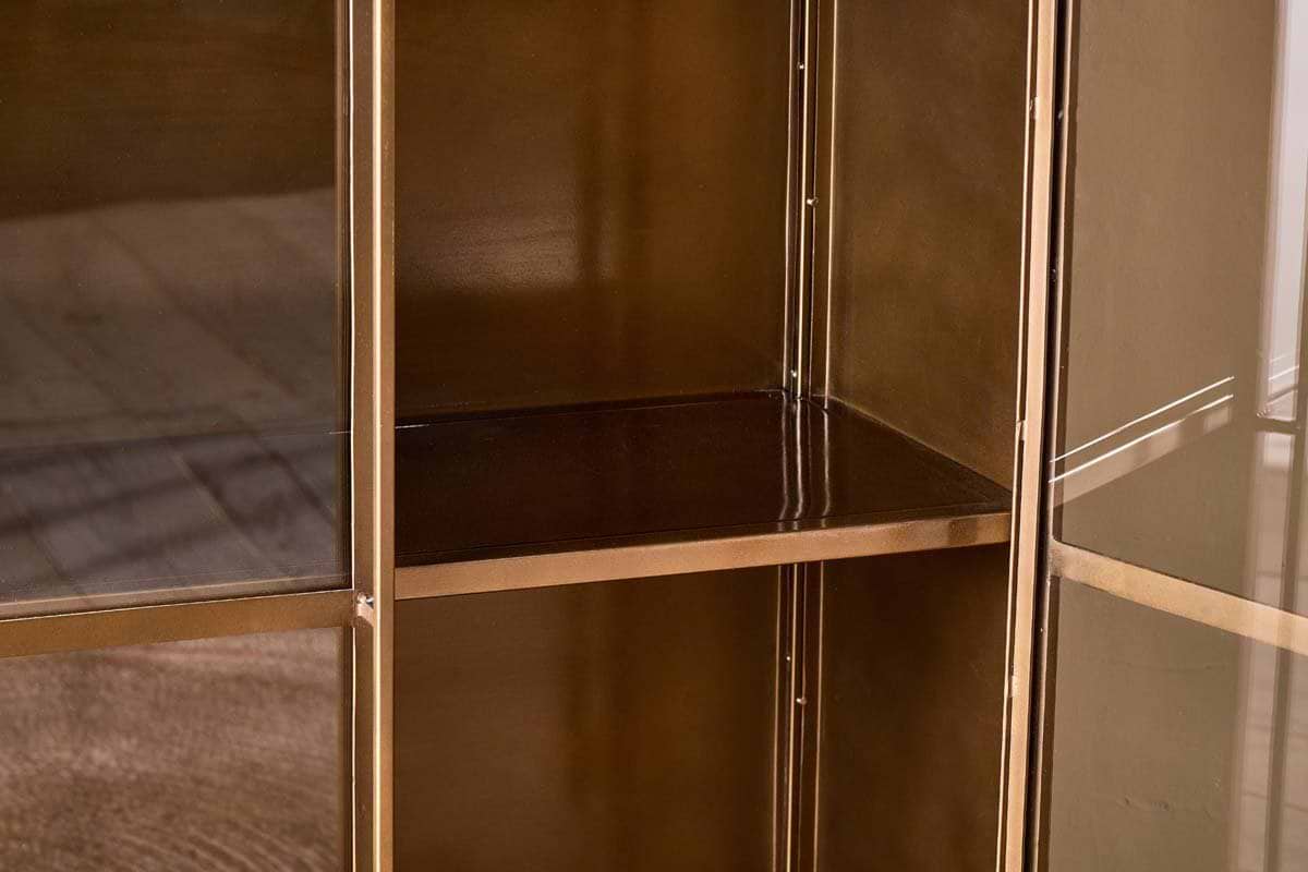 A close-up, interior shot of the nkuku Ranchi Iron Tall Cabinet, featuring glass-fronted doors and at least two shelves, highlights its elegant and timeless design.