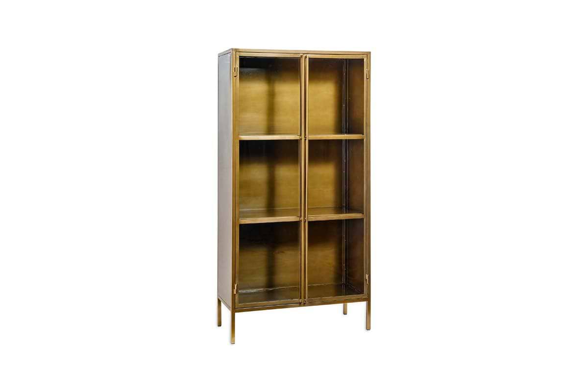 The Ranchi Iron Tall Cabinet by nkuku features a modern metallic gold finish, four shelves, two glass-fronted doors, and slender legs. Photographed against a plain white background.