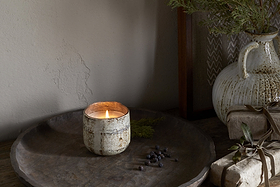 The nkuku Juniper & Fir 1 Wick Scented Candle comes in a reusable vessel, ideal for adding a unique fragrance to any space.