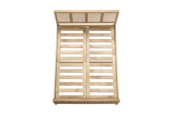 The Saharsa Cane & Mango Wood Bed by nkuku features a slatted headboard and footboard crafted from sustainable mango wood, accented with an elegant handwoven cane detail.