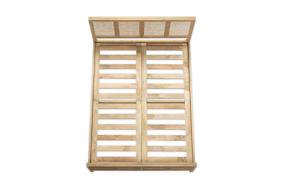 The Saharsa Cane & Mango Wood Bed by nkuku features a slatted headboard and footboard crafted from sustainable mango wood, accented with an elegant handwoven cane detail.