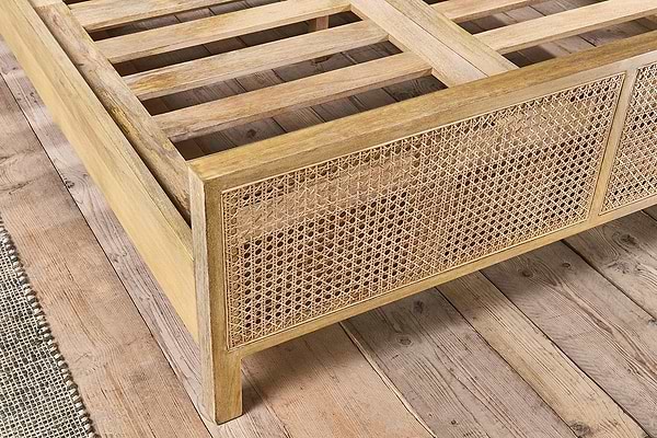 The nkuku Saharsa Cane & Mango Wood Bed features a sustainable mango wood frame, handwoven cane headboard, and slatted base, perfect for wooden floors.