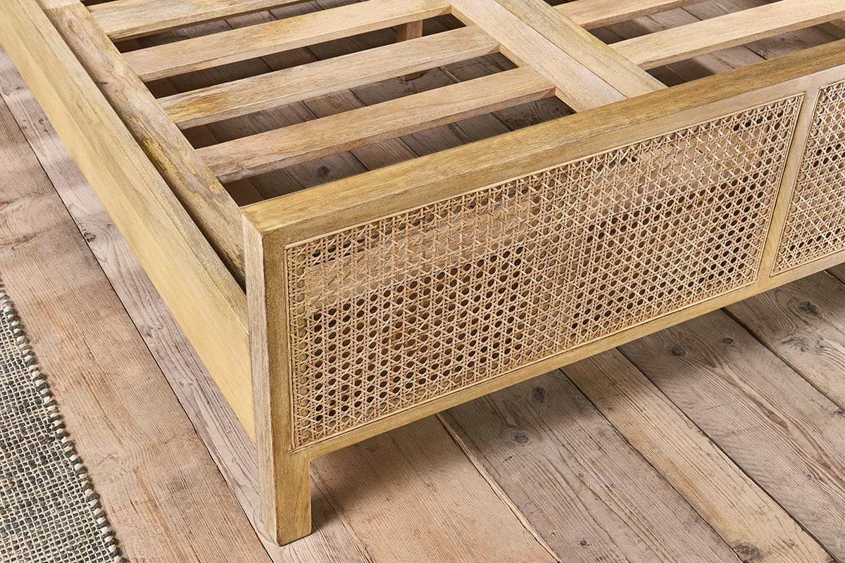 The nkuku Saharsa Cane & Mango Wood Bed features a sustainable mango wood frame, handwoven cane headboard, and slatted base, perfect for wooden floors.