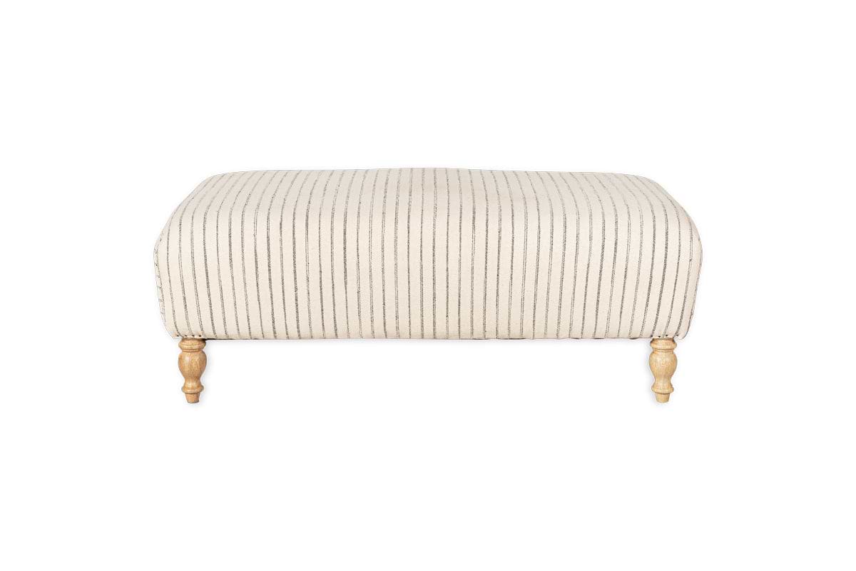 The nkuku Sanja Stripe Upholstered Ottoman in Off White features vertical black stripes on natural linen, four short turned wooden legs with a natural finish, and is showcased against a plain white backdrop for modern appeal.