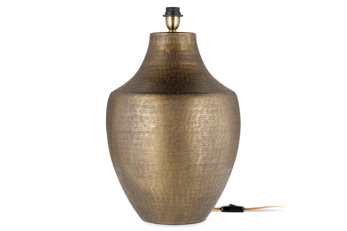 The nkuku Tanda Etched Statement Table Lamp in Antique Brass (Extra Large) features a textured, metallic gold vase-like base with a narrow neck and black socket. An electrical cord with switch extends from its base against a plain white background.